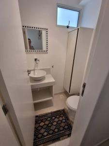 y baño con aseo, lavabo y espejo. en LINDISSIMO IPANEMA, 2 SUÍTES, en Río de Janeiro