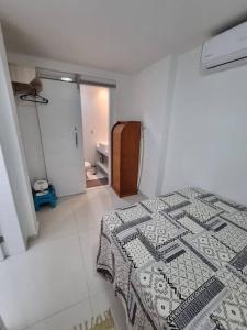 Un dormitorio con una cama con una manta. en LINDISSIMO IPANEMA, 2 SUÍTES en Río de Janeiro