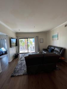 a living room with a black couch and a large window at SoCal LA LUX on 3rd in Los Angeles