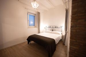 a bedroom with a bed and a window and a chandelier at Sa ia Suite 2 in Cagliari