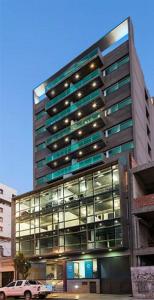 un bâtiment avec une voiture garée devant dans l'établissement San Martín Apart, à San Salvador de Jujuy