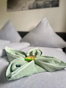 a green blanket laying on top of a bed at Ferienwohnungen Anne in Schönebeck