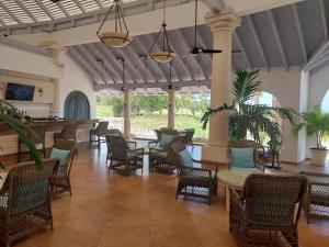 a lobby with chairs and tables and a bar at Coconut Grove 8 Luxury Villa by Island Villas in Saint James