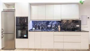 eine Küche mit weißen Schränken und einem Kühlschrank in der Unterkunft Cortijo La Venta Hoyo in Nigüelas