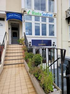 a building with a staircase in front of a building with a sign at Atlantic Seafront in Brighton & Hove