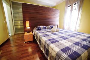 um quarto com uma cama grande e uma cabeceira em madeira em Canela Homes BARCELONA JARDINETS em Barcelona