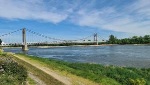 a suspension bridge over a river with water at Chez pat in Ancenis