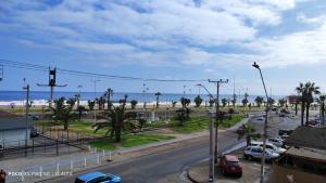 a city street with cars parked on the beach at Hotel La Carreta Playa Brava in Iquique