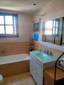 een badkamer met een bad, een wastafel en een bad tubermottermott bij Centrale vista mare in Torremolinos