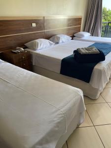 2 Betten in einem Hotelzimmer mit weißer Bettwäsche in der Unterkunft GUTIERREZ HOTEL in Americana
