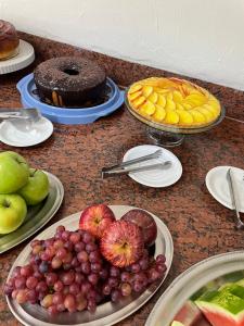 einen Tisch mit Obstteller und Kuchen in der Unterkunft GUTIERREZ HOTEL in Americana