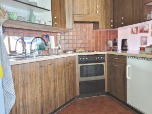 a kitchen with wooden cabinets and a sink and a dishwasher at SunShine in Pany