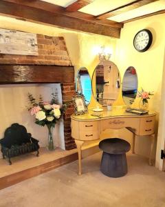 a dressing room with a desk and a mirror at Shoemakers Cottage, Halesworth in Halesworth