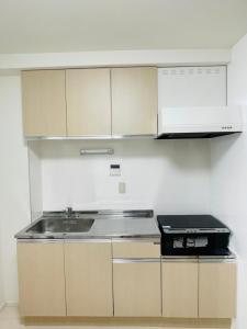 a kitchen with a sink and a stove at STUDIO YONEGAHAMA l 米が浜通 in Yokosuka