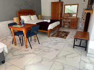 a bedroom with a bed and a table and chairs at The Solomon Guest House in Kimberley