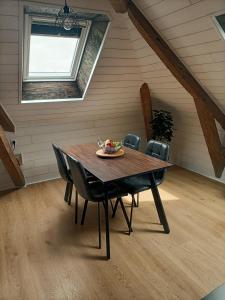 un comedor con mesa y sillas en un ático en Cocoon Boisé, en Les Portes du Coglais