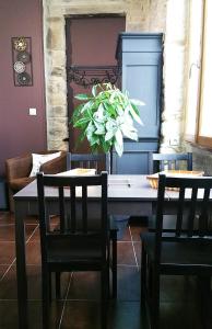 une salle à manger avec une table, des chaises et une plante dans l'établissement LE P'TIT APPART, à Landerneau