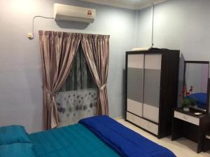 a bedroom with a blue bed and a window at KJ Homestay Balok Kuantan in Kampong Chengal Lempong