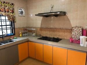 a kitchen with orange cabinets and a sink at KJ Homestay Balok Kuantan in Kampong Chengal Lempong