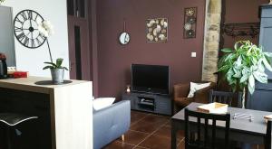 - un salon avec un canapé et une télévision dans l'établissement LE P'TIT APPART, à Landerneau