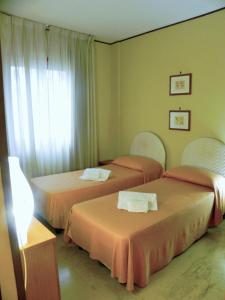 two beds in a hotel room with a window at Torreata Hotel & Residence in Palermo