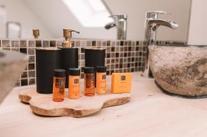 een groep van vier flessen essentiële oliën op een aanrecht in een badkamer bij Holiday Home Relax in Ieper