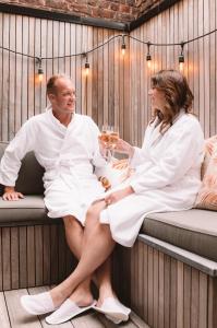 een man en vrouw op een bank met een glas wijn bij Holiday Home Relax in Ieper