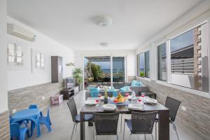 een eetkamer en een woonkamer met een tafel en stoelen bij Villa Suri, Luxury Seafront Villa in Ayia Napa