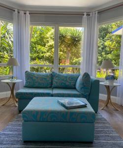 a living room with a blue couch and a large window at Quinta dos Bravos in Pico da Pedra