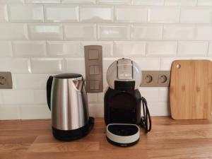 Una licuadora colocada sobre un mostrador junto a una cafetera. en L'Oustalet d'Erine - spacieuse et climatisée, en Albi