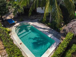 una piscina en un patio con una palmera en Villa Jupiter - Watamu, en Watamu