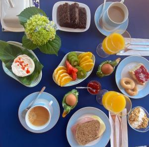 una mesa azul con platos de comida y tazas de café en Quinta dos Bravos en Pico da Pedra