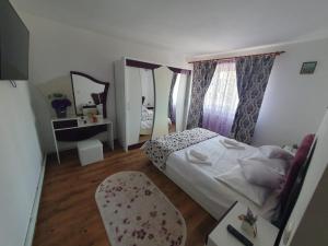 a bedroom with a bed and a table and a chair at Apartament Centru Vatra in Vatra Dornei