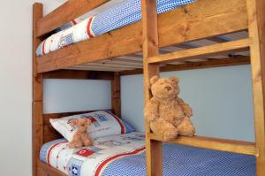 two teddy bears sitting on a bunk bed at Springwell , West Wittering in West Wittering