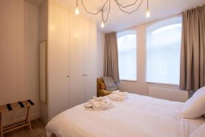 - une chambre avec un grand lit blanc et une fenêtre dans l'établissement Holiday Home Relax, à Ypres