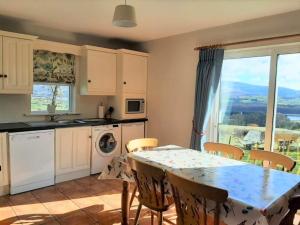 uma cozinha com uma mesa e cadeiras e uma cozinha com uma janela em Abhainn Ri Cottages em Blessington