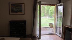 a bedroom with a sliding glass door to a deck at Hôtel sud alsace in Ranspach-le-Bas