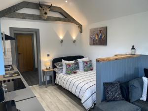 a small bedroom with a bed and a couch at Wellsfield Farm Holiday Lodges in Stirling