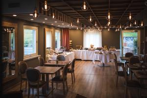 jadalnia ze stołami, krzesłami i światłami w obiekcie Lake Hotel La Pieve w mieście Pisogne