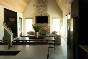 uma cozinha e sala de estar com uma mesa e uma lareira em NEW Creek Side, Luxury Cabin – Willow Creek em Stephens Gap