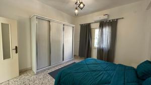 a bedroom with a blue bed and a window at Turkuaz Aparment in Amman