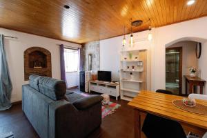 ein Wohnzimmer mit einem Sofa und einem Tisch in der Unterkunft Casa do Javali in Bragança