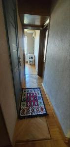 a hallway with a door and a rug on the floor at Уютная трехкомнатная квартира с видом на море в Баку in Baku