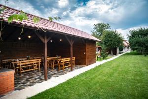 un restaurante con mesas de madera y césped verde en Magda Garden en Cîrţişoara