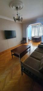 a living room with a table and a couch at Уютная трехкомнатная квартира с видом на море в Баку in Baku