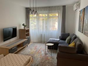 a living room with a couch and a tv at COOKIE Apartment in Zagreb