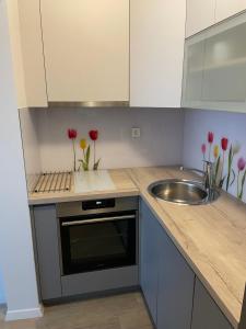 a kitchen with a sink and a counter with flowers at COOKIE Apartment in Zagreb