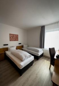 a hotel room with two beds and a window at Hotel Schmidt garni in Essen