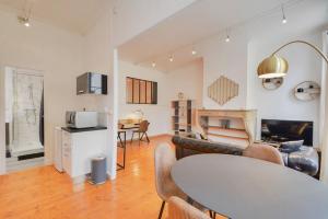 a living room with a table and a kitchen at Le Discret de la Craffe - A 5 min de la Place Stanislas in Nancy