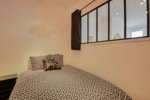 a bedroom with a bed and a large window at Le Discret de la Craffe - A 5 min de la Place Stanislas in Nancy
